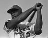 Waist-up portrait of black baseball batter at end of swing