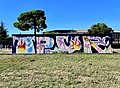 Graffiti de OPUR, pièce picturale s'intégrant dans le street art par le mélange de lettres et de motifs colorés.