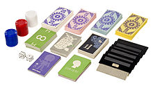 Plusieurs tas de cartes à joueur, de jetons et des dés et des cartouches de jeux.