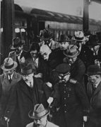 photo prise sur un quai de gare. Au centre un homme inconscient est entouré et porté par une dizaine d'hommes.