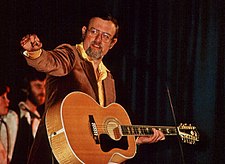 O cantaire, compositor y musico britanico Roger Whittaker, mientres una actuación en os escenarios en 1976.