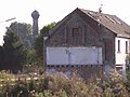 Im Vordergrund bereits abgebrochenes Haus, Wasserturm im Hintergrund