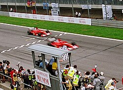 Michael Schumacher passerar Rubens Barrichello intill mållinjen vid Österrikes Grand Prix 2002.