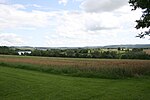 Ansicht des Kastellgeländes (hellgrünes Gelände) von Norden. Links der Bucher Stausee, am Horizont Schloss Kapfenburg.