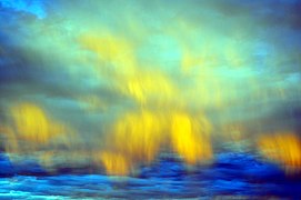 Illuminated downdraft wind shear clouds in the eastern sky near dusk mimic aurora borealis in the Mojave Desert