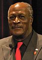 John Amos interpreta "Burt" Guster