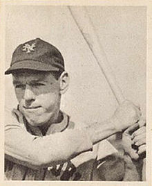 A man in a light baseball jersey and dark cap