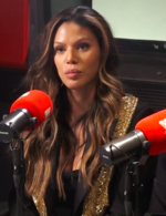 A 44-year-old black woman with long, brown hair and blonde streaks, looking at something to the left of the camera.