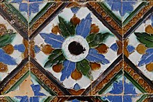 A tile with an ornate, colorful radial pattern