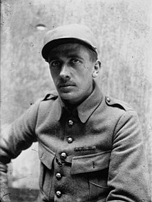 Photographie en noir et blanc d'un homme assis en tenue de soldat.