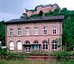 Empfangsgebäude des ehemaligen Bahnhofs Ebernburg, Gleisseite, im Hintergrund die gleichnamige Burg, 2012