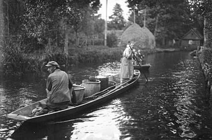 Transport de marchandises en canot dans la forêt en 1930