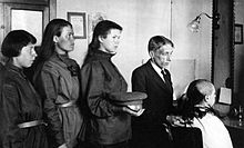Ženy v ruských uniformách stojící ve frontě na ostříhání vlasů.