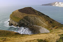 Image of cove with Worbarrow tout featured prominently in the center protruding into the water