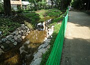 新宿御苑北縁の“散歩道”[16]。 直下にあるトンネルに湧く水を汲み上げて利用。トンネルに並行して玉川上水の遺構が埋まっている。 （新宿区内藤町・新宿1丁目、北緯35度41分15.97秒 東経139度42分42.52秒﻿ / ﻿北緯35.6877694度 東経139.7118111度﻿ / 35.6877694; 139.7118111﻿ (新宿御苑北縁の散歩道)）