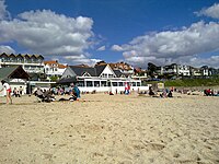 Spiaggia di Gyllyngvase a Falmouth, che mostra il ristorante e gli hotel sul lungomare.