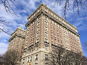 Photo looking upwards at a large, rectangular high-rise apartment building