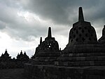 A terraced pyramid like structure with a stupa on top.