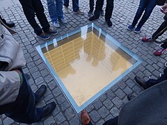 Les visiteurs regardent à travers le verre la bibliothèque souterraine.