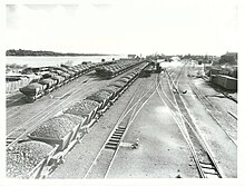 Loaded rail coal trucks, rail tracks and the river on the left