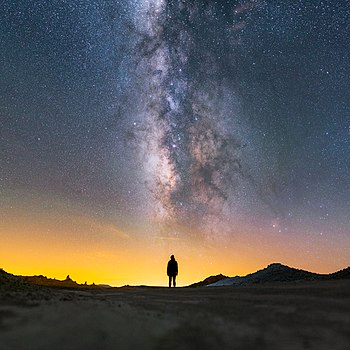 Mléčná dráha nad siluetou ženy v kalifornském skalním útvaru Trona Pinnacles