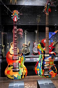 The Fool SG (1964 Gibson SG) played by Eric Clapton, and The Fool Bass VI (1962 Fender Bass VI) played by Jack Bruce - both painted in 1967 by The Fool Collective - Play It Loud. MET (2019-05-13 19.29.06 by Eden, Janine and Jim).jpg