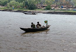 Two Bangladeshi fisherman tending their nets on their country boat in Ichamati river. The river Bank is Sripur town in Khulna division, Bangladesh. Photo taken from a steamer.jpg