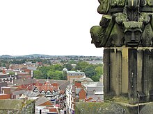 Wrexham town centre overlooked by 16th century grotesques on one of the sixteen pinnacles of St Giles' Church .jpg