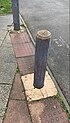 Wooden bollard painted grey, some paint is worn away