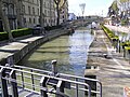 The Canal de la Robine in 2003. (Taken from the "Passerelle entre Deux Villes" pedestrian bridge, facing northwest, away from the heart of the city.)