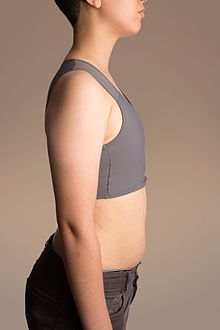 foto de perfil de una persona joven con un tipo de sujetador deportivo especial que aplana sus tetas