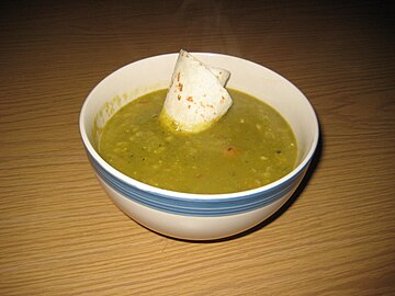 A thick pea soup garnished with a tortilla accent