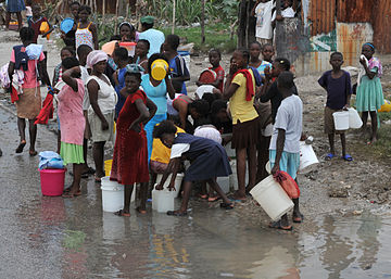 Haitianos esperando recolectar un poco de agua.