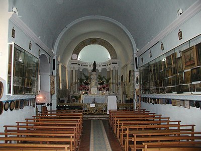 Intérieur de la chapelle Notre-Dame-des-Anges et ses ex-voto. La vierge noire est posée sur un autel en marbre.