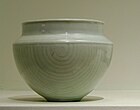 A blue-grey bowl with a nearly perfect half sphere body, and a rim that narrows from the edge of the half sphere, then goes up slightly.