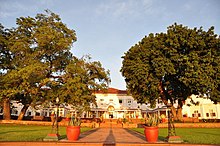 Photographie d'un grand bâtiment blanc de style colonial