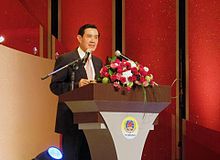 Ma Ying-jeou dempeus darrere un faristol adornat amb flors