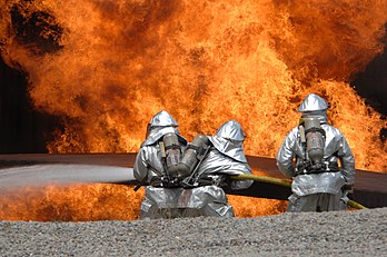 Des pompiers américains (ici ingénieurs civils de protection contre le feu employés par l’US Air Force) dans un exercice de lutte anti-incendie sur un site d’entraînement. (définition réelle 4 288 × 2 848)
