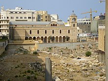 A large church at the edge of an archaeological field.