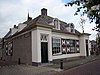 Sluiswachtershuis onder mansardedak, lage woning, centrale schoorsteen