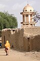 A woman is walking past the Mosque, Dori, Burkina Faso, 2010