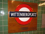 En skylt på Wittenbergplatz station med design inspirerad av Londons tunnelbanas stationsskyltar. En gåva från London 1952.