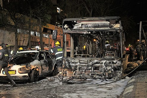 Bus and car burnt out after rocket hit in Holon, in coastal Israel