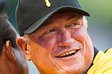 A man in a yellow baseball jersey and black cap