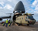 un énorme hélicoptère sort de la porte avant d'un C-5.