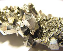 A lump of gray shining crystals with hexagonal facetting