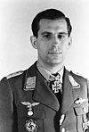 A man wearing a military uniform with an Iron Cross displayed at the front of his uniform collar.