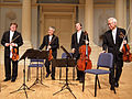 Image 17A modern string quartet. In the 2000s, string quartets from the Classical era are the core of the chamber music literature. From left to right: violin 1, violin 2, cello, viola (from Classical period (music))