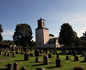 Vy över kyrkan med kyrkogården i förgrunden.