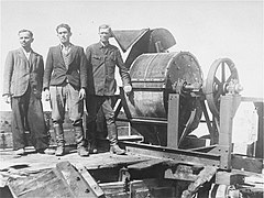 Jewish prisoners forced to work for a Sonderkommando 1005 unit pose next to a bone crushing machine in the Janowska concentration camp.jpg